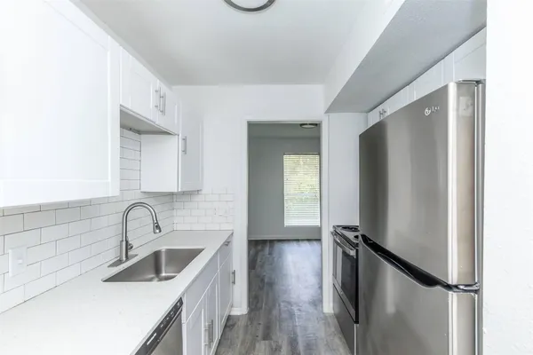 a kitchen with sink a refrigerator and window