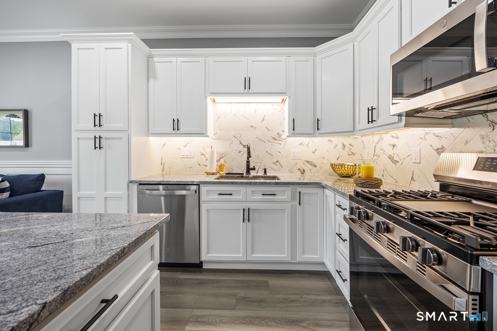 210 Munson Road, Unit 2G Wolcott, CT 06716 - Photo 4 of 23 a kitchen with kitchen island granite countertop a sink cabinets and stainless steel appliances