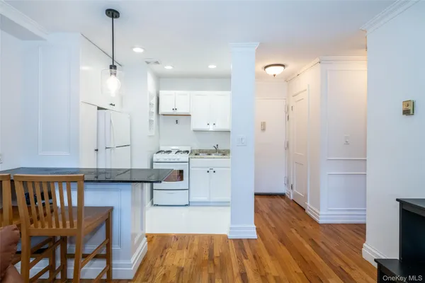 a kitchen with white cabinets and black appliances