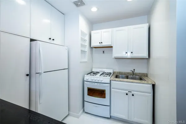 a kitchen with a refrigerator sink stove and cabinets