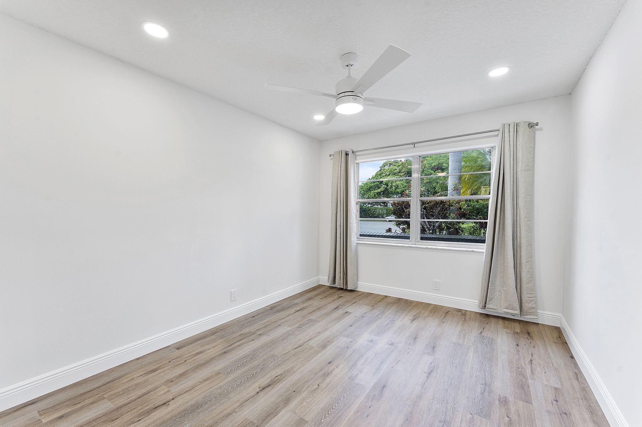 9180 Pine Springs Drive Boca Raton, FL 33428 - Photo 19 of 29 an empty room with wooden floor and windows