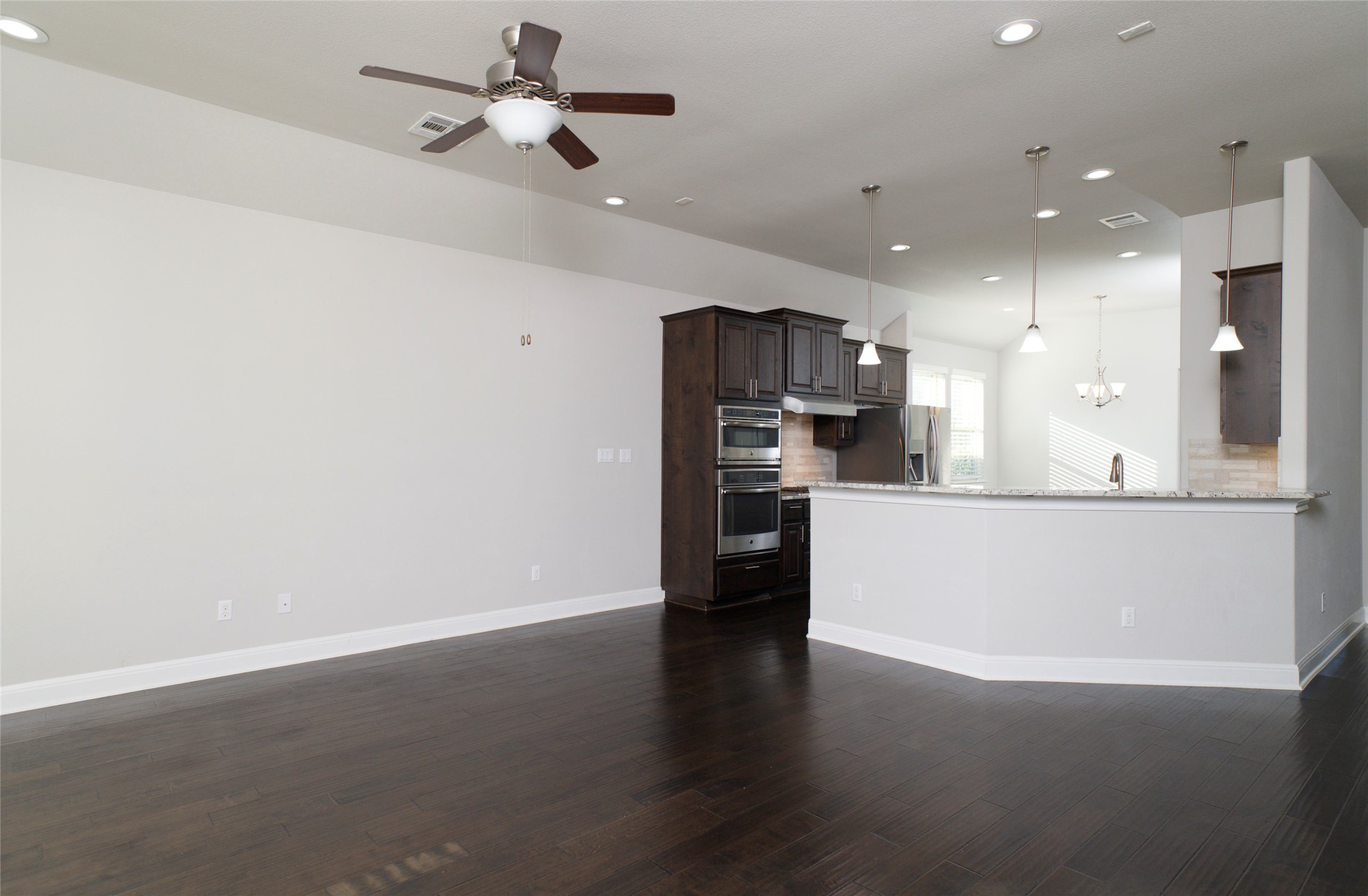4001 Goodnight Trail Leander, TX 78641 - Photo 12 of 35 a view of a kitchen with stainless steel appliances wooden floor and a refrigerator