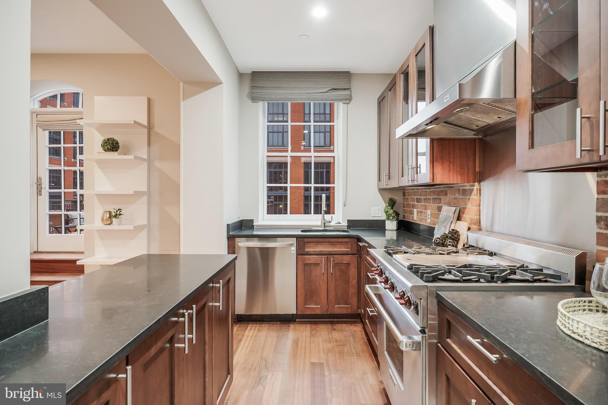 215 I Street Northeast, Unit 401 Washington, DC 20002 - Photo 18 of 36 a kitchen with stainless steel appliances granite countertop a stove a sink and a refrigerator