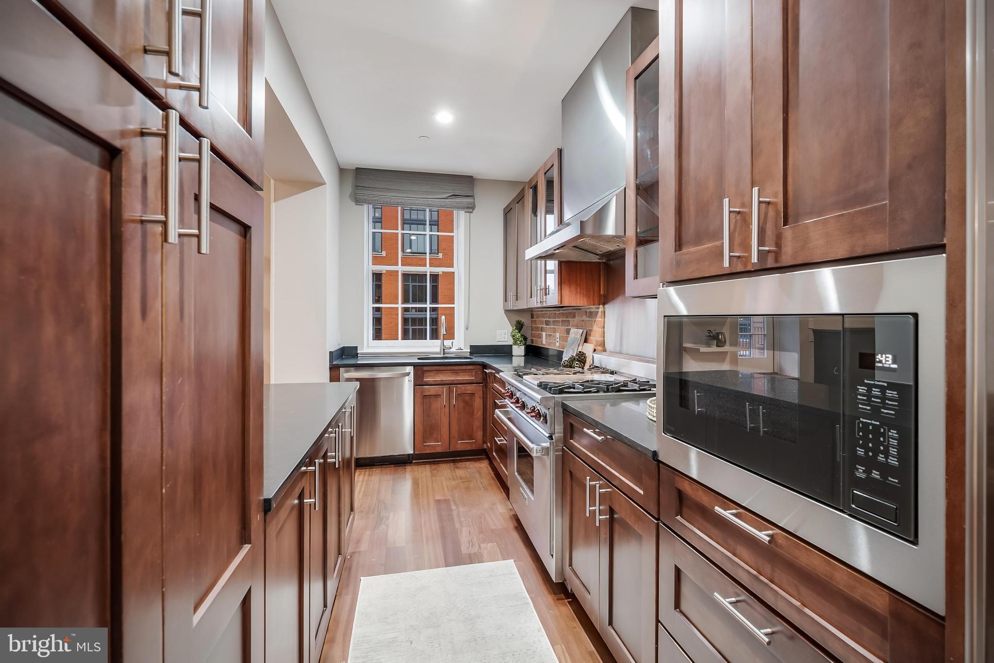215 I Street Northeast, Unit 401 Washington, DC 20002 - Photo 19 of 36 a kitchen with stainless steel appliances granite countertop a stove and a refrigerator