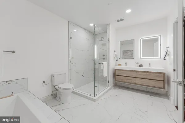 a bathroom with a double vanity sink toilet and shower