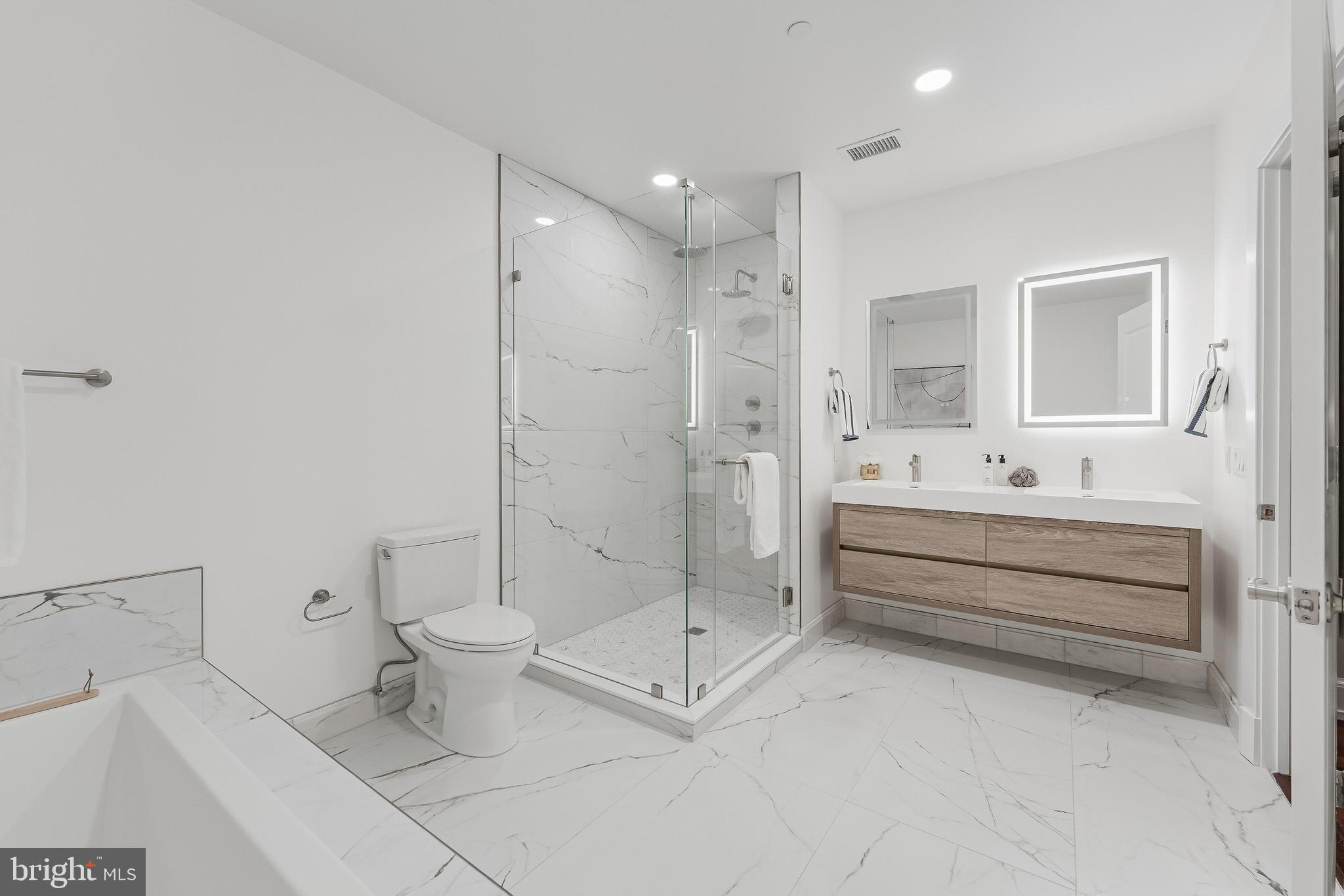 215 I Street Northeast, Unit 401 Washington, DC 20002 - Photo 26 of 36 a bathroom with a double vanity sink toilet and shower
