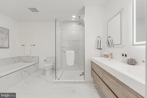 a bathroom with a double vanity sink mirror and shower