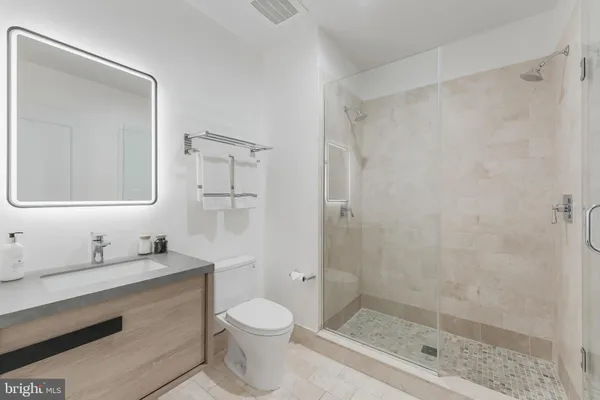 a bathroom with a sink a toilet and shower