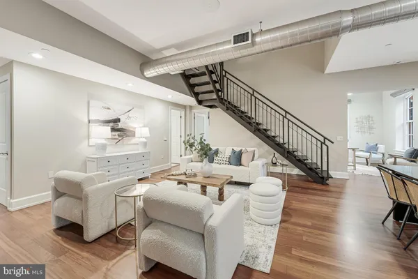 a living room with furniture floor to ceiling window and wooden floor