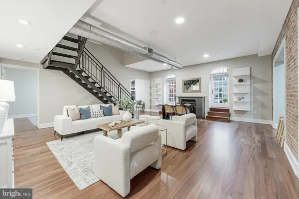 a living room with fireplace furniture and a wooden floor