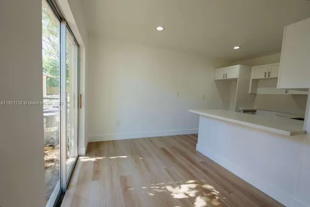 a view of a kitchen with wooden floor and electronic appliances