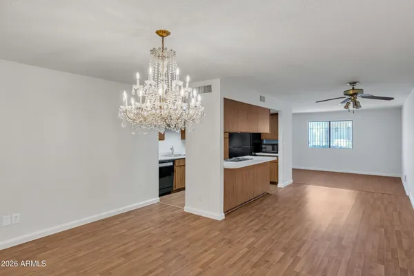 a view of a hallway with wooden floor and a kitchen