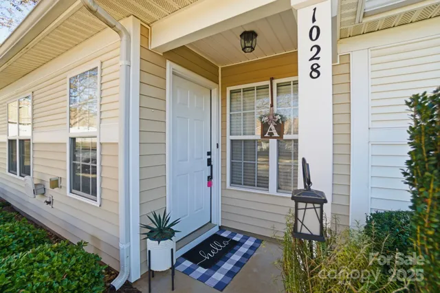 a balcony with table and chairs and potted plants
