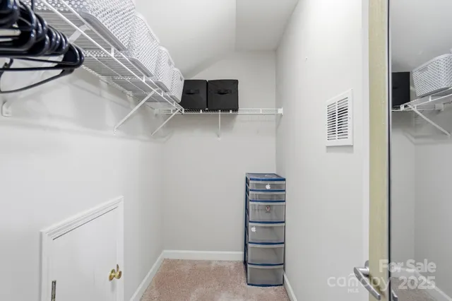 a view of walk in closet with empty racks