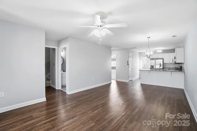 a view of an empty room and kitchen view