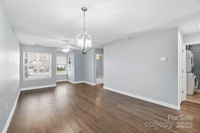a view of empty room with wooden floor and window