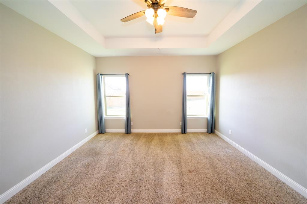 132 Addie Way Tuscola, TX 79562 - Photo 12 of 37 an empty room with a chandelier fan and windows