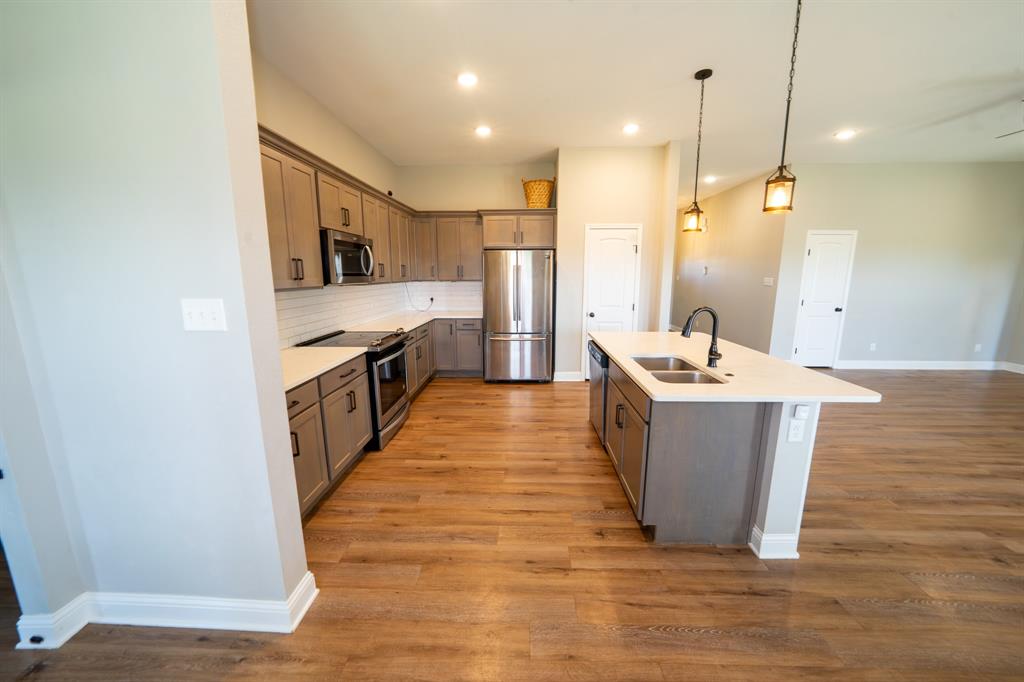 132 Addie Way Tuscola, TX 79562 - Photo 19 of 37 a large room with kitchen island a sink wooden floor and glass door