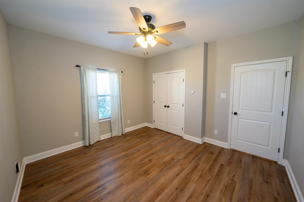 132 Addie Way Tuscola, TX 79562 - Photo 7 of 37 wooden floor in an empty room with a window