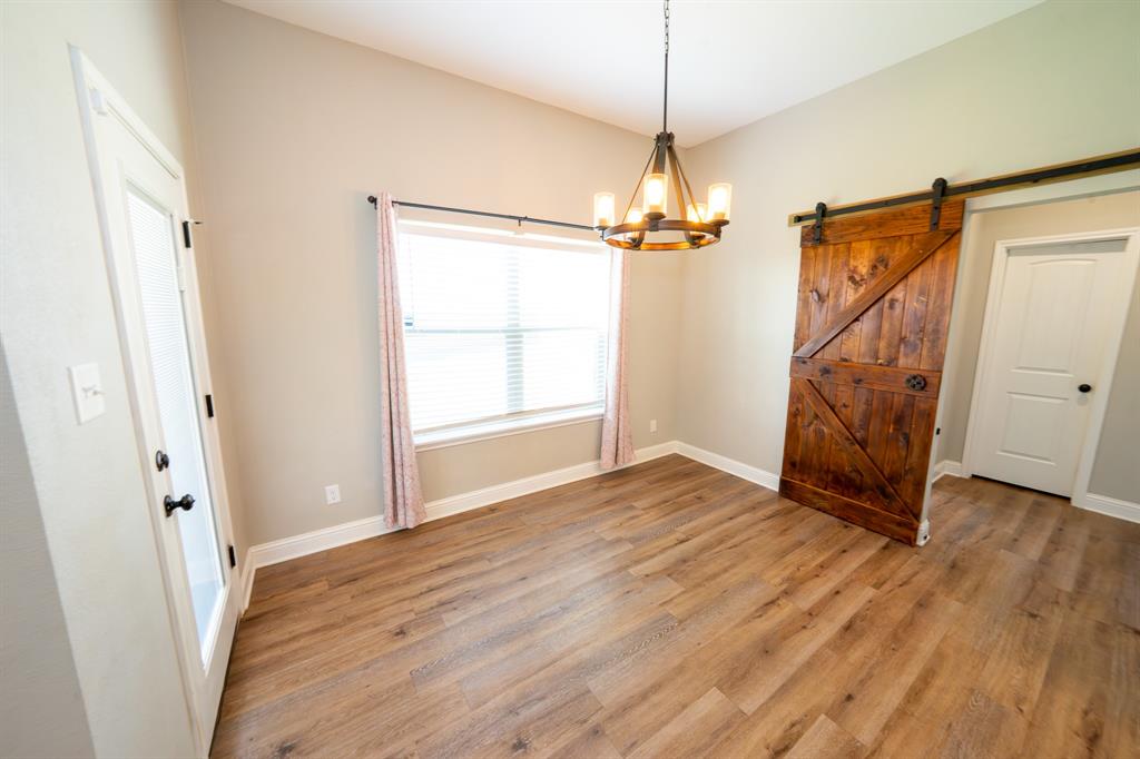 132 Addie Way Tuscola, TX 79562 - Photo 9 of 37 an empty room with wooden floor fan and windows