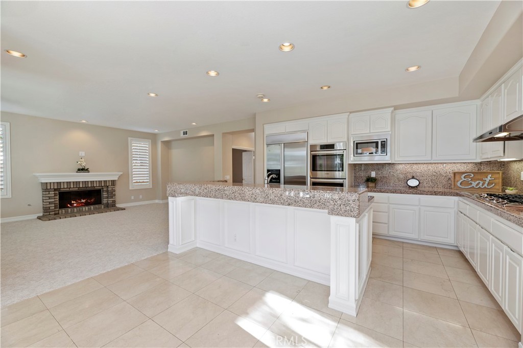 8 Nidden Irvine, CA 92603 - Photo 13 of 77 a large white kitchen with stainless steel appliances granite countertop a stove and a sink