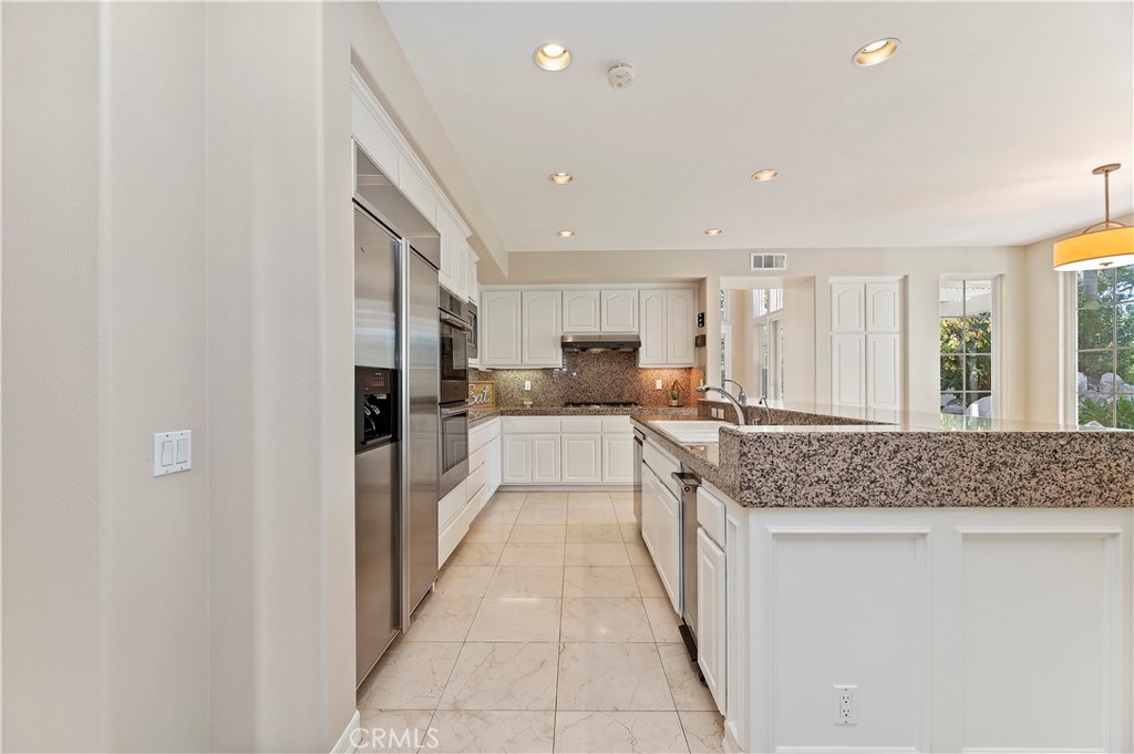 8 Nidden Irvine, CA 92603 - Photo 16 of 77 a kitchen with stainless steel appliances granite countertop a sink and cabinets