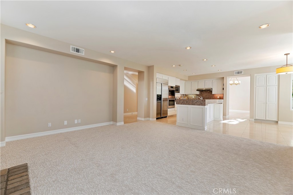 8 Nidden Irvine, CA 92603 - Photo 22 of 77 a view of a kitchen with a refrigerator a kitchen island and a wooden floor