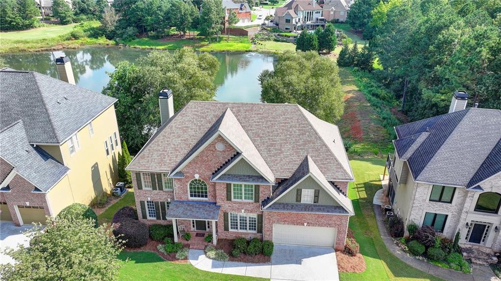 a aerial view of a house next to a yard with plants and large trees