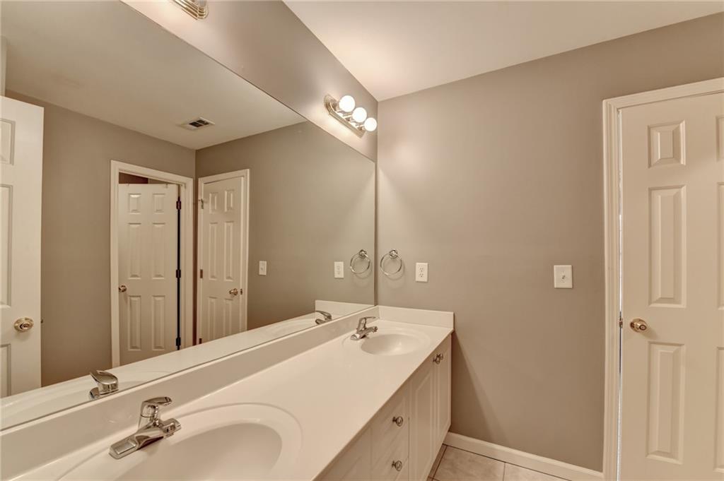 964 Fairview Club Circle Dacula, GA 30019 - Photo 25 of 47 a bathroom with a double vanity sink and a mirror