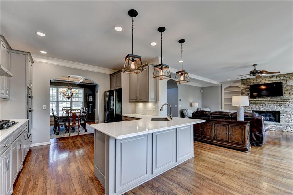 964 Fairview Club Circle Dacula, GA 30019 - Photo 8 of 47 a living room with stainless steel appliances kitchen island granite countertop furniture wooden floor and a view of kitchen
