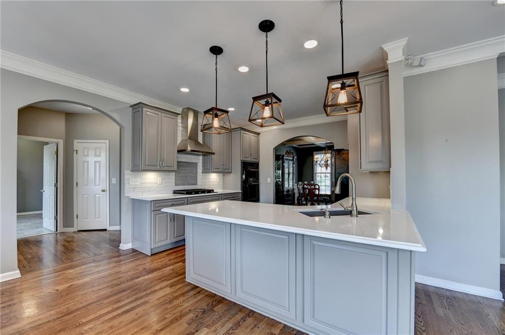 964 Fairview Club Circle Dacula, GA 30019 - Photo 9 of 47 a large kitchen with stainless steel appliances granite countertop a sink a stove and a wooden floors