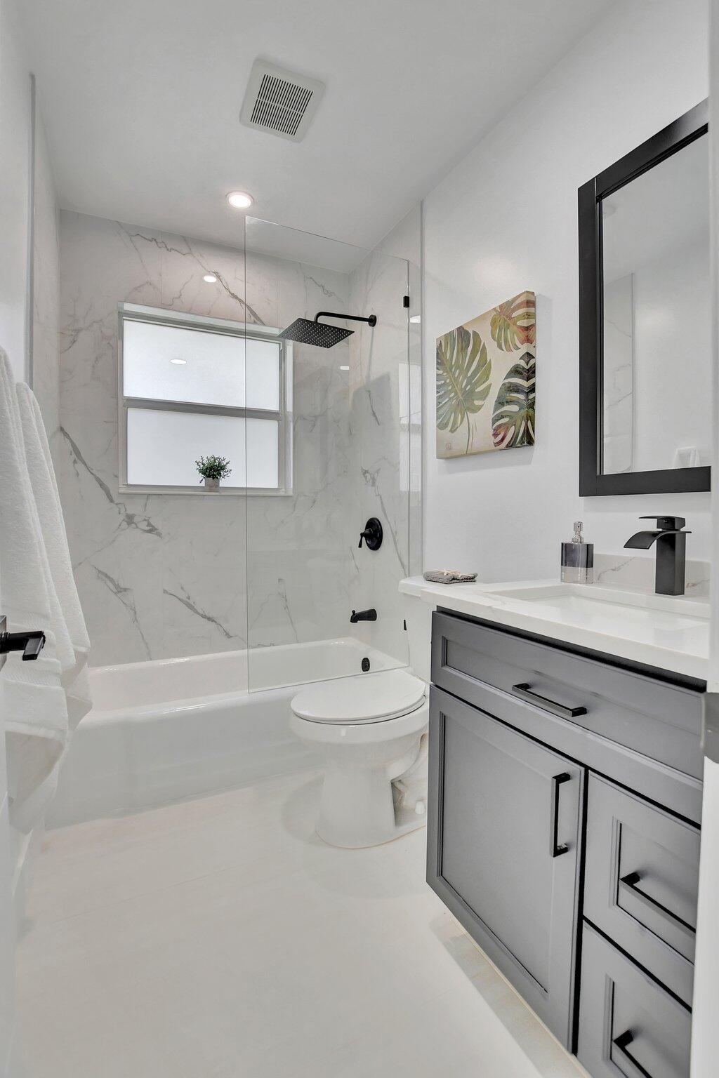 832 Southwest 10th Avenue Boca Raton, FL 33486 - Photo 29 of 57 a bathroom with a bathtub sink mirror and toilet