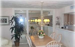 13650 Gulf Boulevard, Unit 304 Madeira Beach, FL 33708 - Photo 26 of 63 a dining room with furniture and chandelier