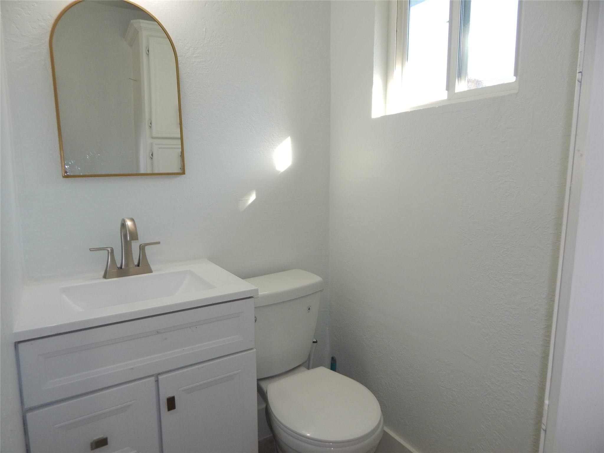 206 Arnett Lane Houston, TX 77037 - Photo 27 of 28 a bathroom with a toilet a sink and mirror