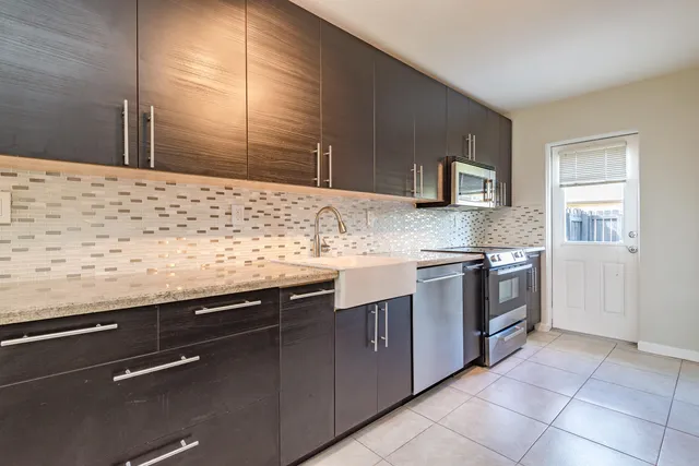 a kitchen with stainless steel appliances granite countertop a sink and a stove