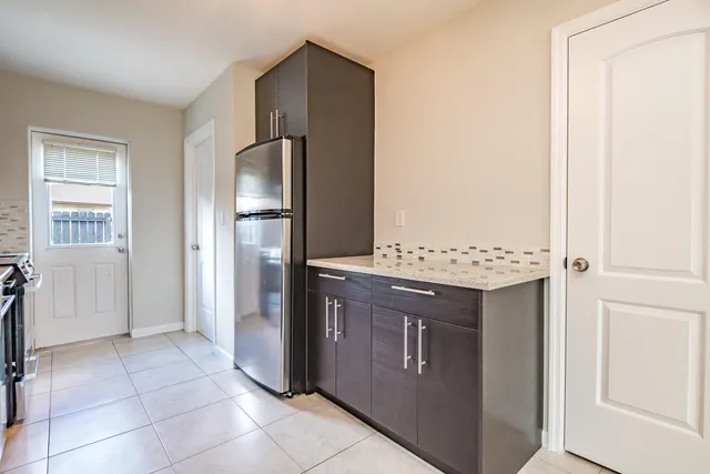 a kitchen with stainless steel appliances granite countertop a refrigerator and a stove