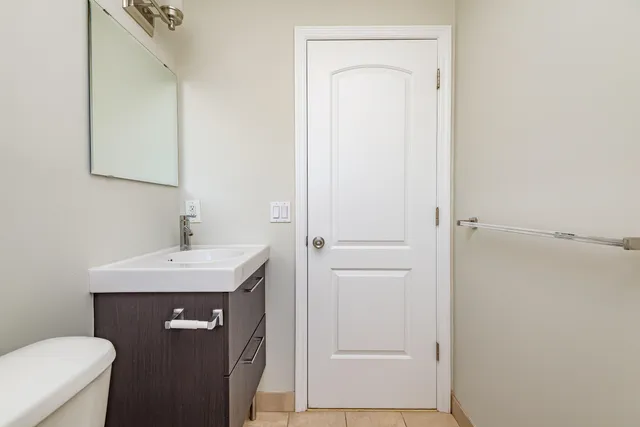 a bathroom with a sink a toilet and a mirror