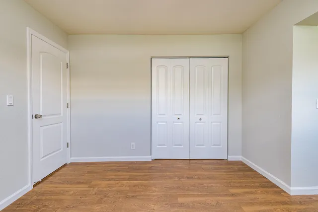a view of an empty room with wooden floor
