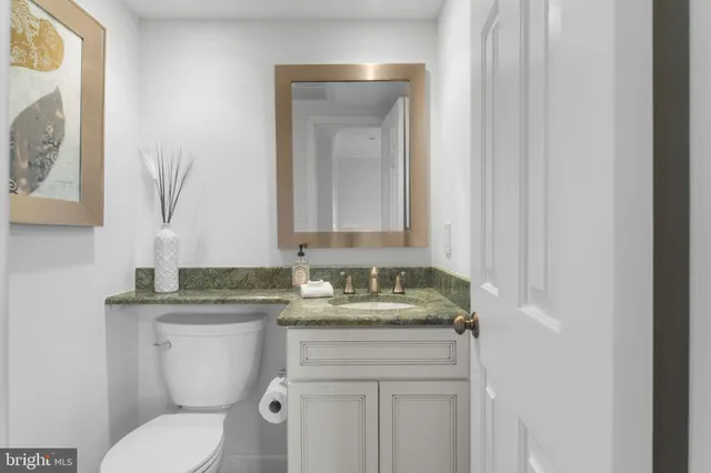 a bathroom with a granite countertop sink a toilet and bathtub