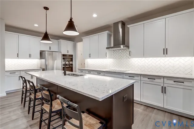a kitchen with kitchen island a wooden floor and white cabinets
