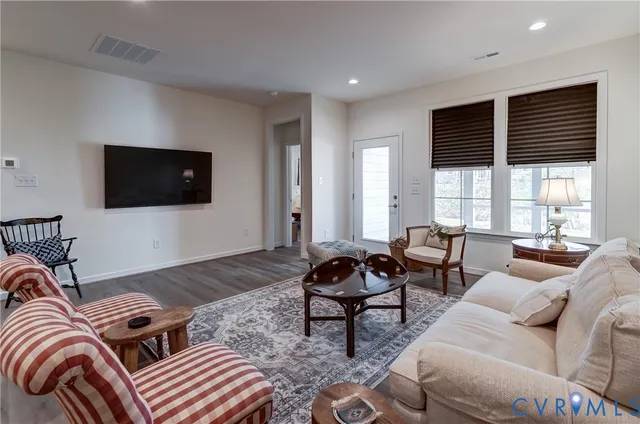 a living room with furniture a flat screen tv and a large window