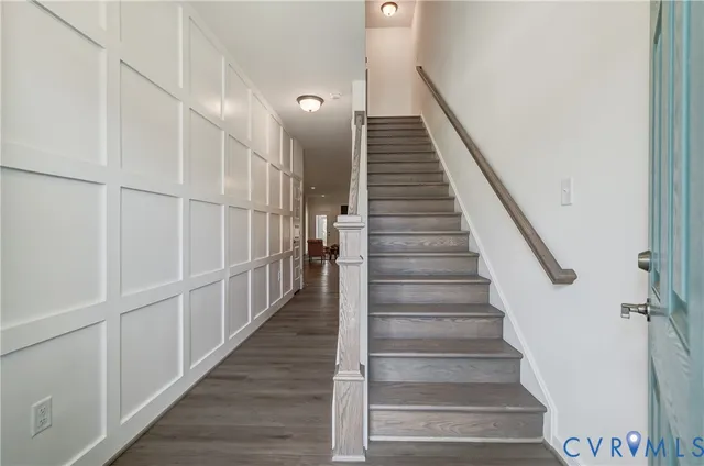 a view of staircase with wooden floor and white walls