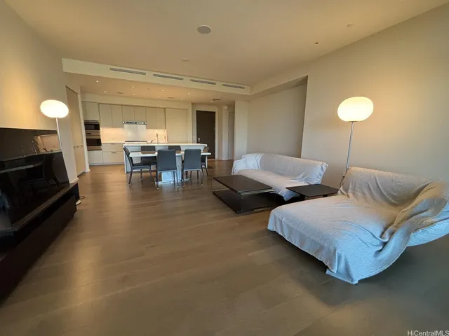a living room with couches and kitchen view
