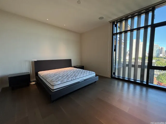 a bedroom with a bed and wooden floor