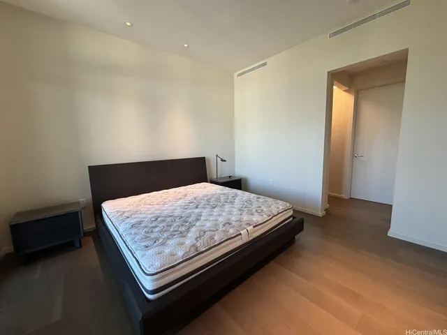 a bed sitting in a bedroom next to a cabinet