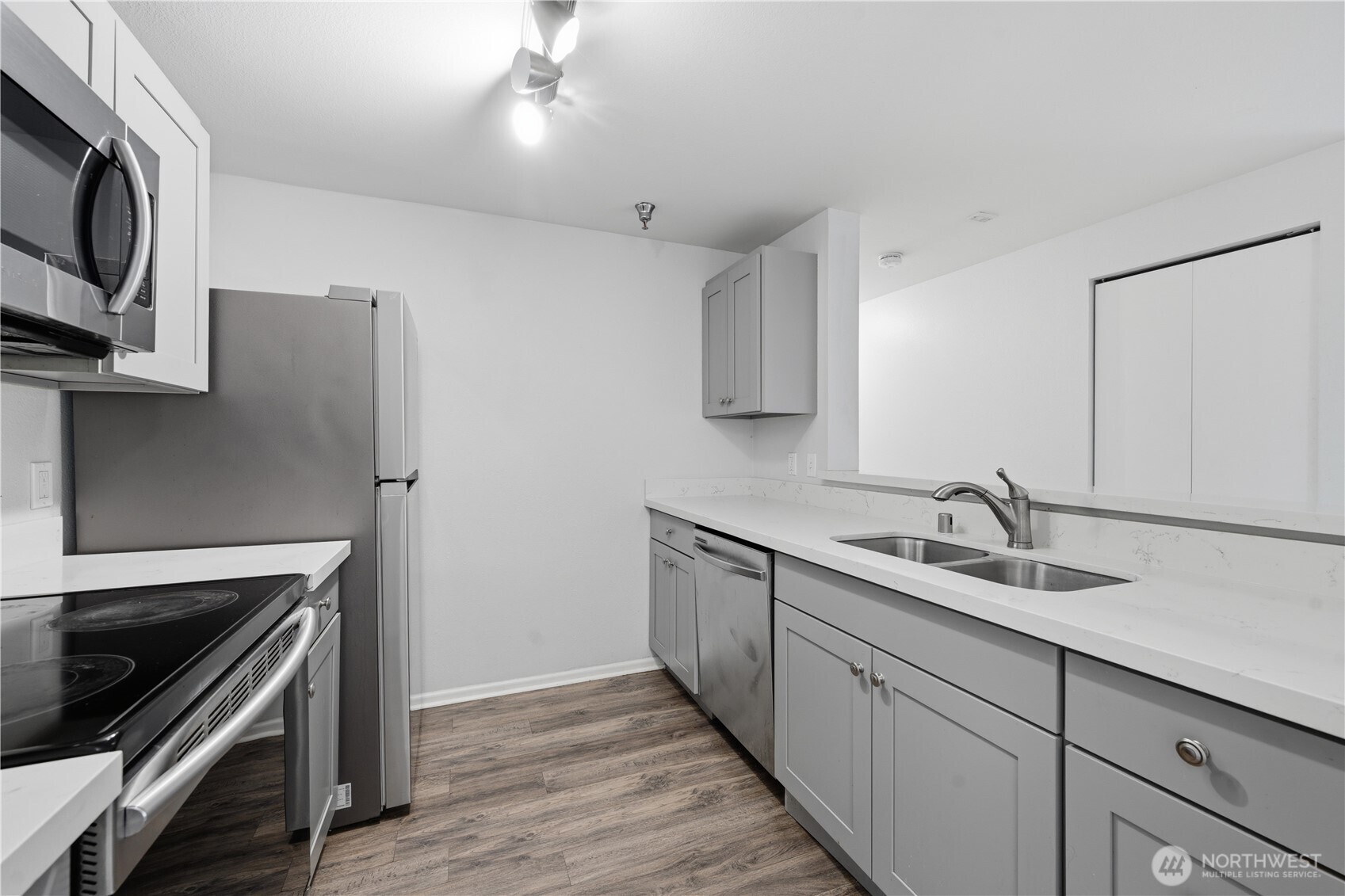 975 Aberdeen Avenue Northeast, Unit F308 Renton, WA 98056 - Photo 8 of 20 a kitchen with cabinets stainless steel appliances a sink and wooden floor
