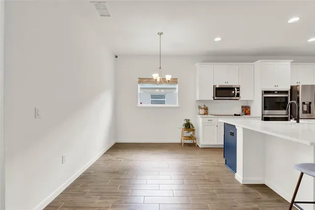 a kitchen with white cabinets and white appliances