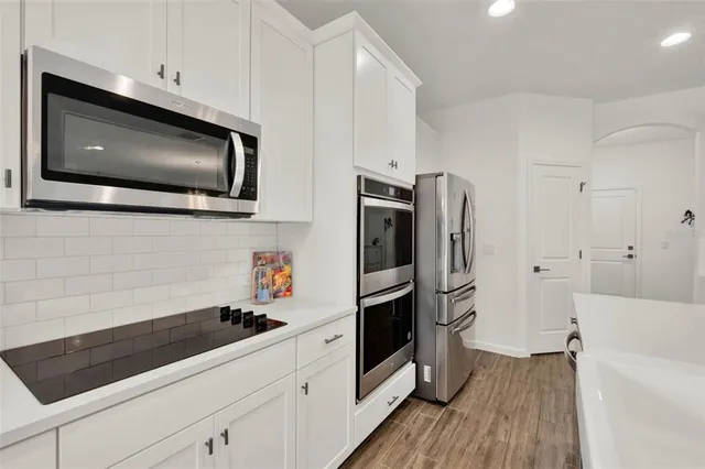 a kitchen with stainless steel appliances a microwave a stove and cabinets