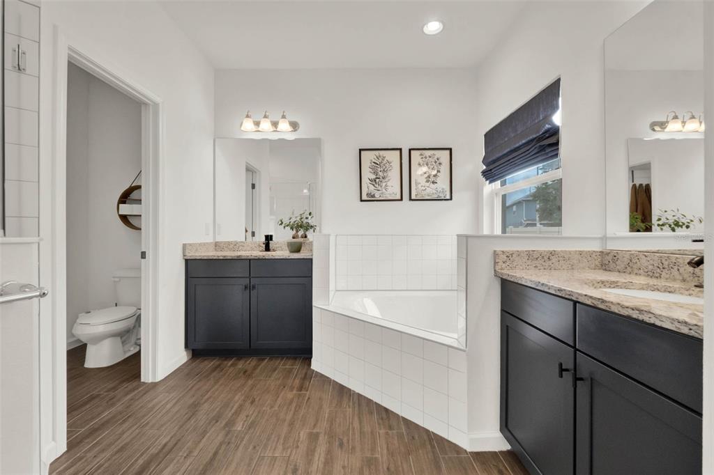 533 Avila Place Howey-in-the-Hills, FL 34737 - Photo 23 of 42 a bathroom with a granite countertop toilet sink and mirror