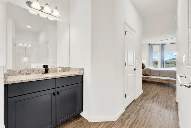 a bathroom with a granite countertop toilet sink and mirror